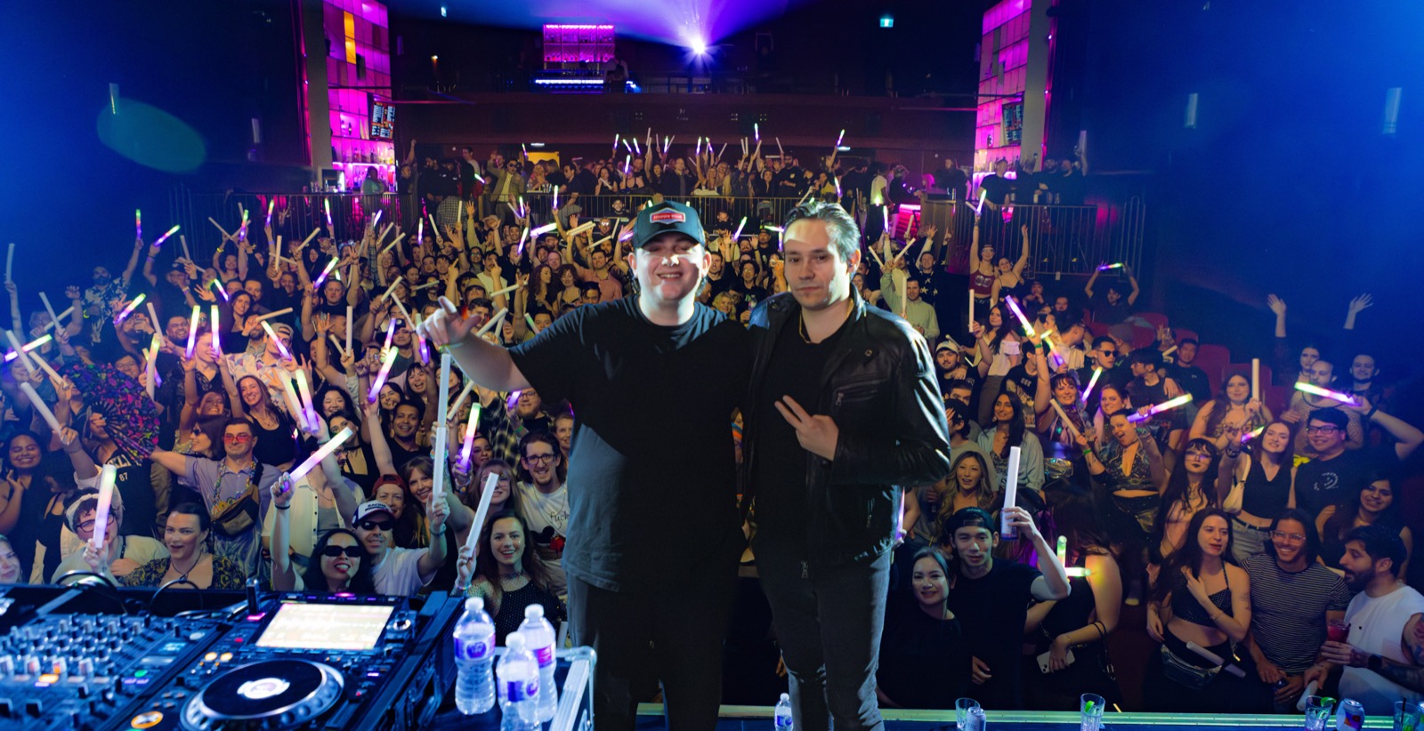 Packed event crowd with glow sticks at a Jakoa production